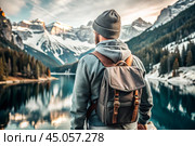 A man with a backpack on his back against the background of a blue lake in a forest in the mountains. The guy travels and enjoys life and the environment. Tourism. Стоковое AI-изображение, AI-художник Photojuli / Фотобанк Лори