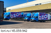 Moscow September 08 2024. A row of blue and red trucks with the word "ozon" on the side. Редакционное фото, фотограф Скрипачев Антон / Фотобанк Лори