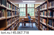 A student studies quietly at a library desk surrounded by bookshelves during the afternoon. Стоковое AI-изображение, AI-художник Сергей Толмачёв / Фотобанк Лори