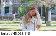Blonde Hair. Young beautiful woman dissolves her long hair sitting on bench in summer park. Стоковое видео, видеограф Андрей Аркуша / Фотобанк Лори