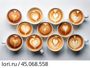 Lots of mugs of different coffee and coffee drinks on a white table. Top view, flat lay. Стоковое AI-изображение, AI-художник Photojuli / Фотобанк Лори