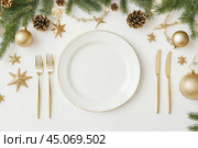 White empty dinner plate on Elegant Festive Table Setting. Beautiful Holiday Decor for Celebrations. Chic plate arrangement adorned a gold accents and winter decoration. Top view, flat lay, copy space. Стоковое AI-изображение, AI-художник Марина Демидюк / Фотобанк Лори
