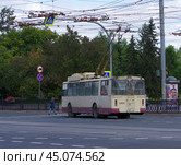 Троллейбус ЗиУ-682Г [Г00] №2454 пропускает пешехода на пешеходном переходе. Челябинск, проспект Свердловский (2024 год). Редакционное фото, фотограф Алексей Иванов / Фотобанк Лори
