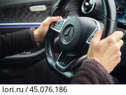 A man drives a Mercedes holding the steering wheel with two hands - Moscow, Russia, October 04, 2024. Редакционное фото, фотограф Андрей Журавлев / Фотобанк Лори