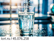 Drinks. A glass of crystal clear fresh drinking water on the table in the home interior. Стоковое AI-изображение, AI-художник Photojuli / Фотобанк Лори