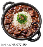 Brazilian feijoada with rice and parsley in black clay pot. Стоковое AI-изображение, AI-художник Иван Рябоконь / Фотобанк Лори