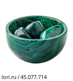 Polished malachite bowl holding tumbled stones. Стоковое AI-изображение, AI-художник Иван Рябоконь / Фотобанк Лори