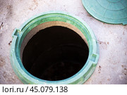 Construction of a septic tank. Large concrete rings with an open sewer hatch, unprotected by a cover from falls and accidents. Стоковое фото, фотограф Коханова Наталья / Фотобанк Лори