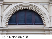 Close up view on a  semicircular window on a facade of white stone ancient building with carved decor. Стоковое фото, фотограф Михаил Строгалев / Фотобанк Лори