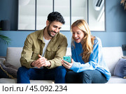Happy man and woman have fun browsing the internet on a smartphone. Стоковое фото, фотограф Raquel Corcoles Mendez / Фотобанк Лори