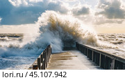 Huge waves crashing on pier during storm surge at sunset. Стоковое AI-изображение, AI-художник Юрий Поздников / Фотобанк Лори
