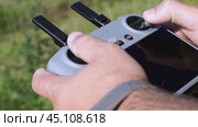 a surveyor on a construction site controls a quadcopter. Стоковое видео, видеограф Igor Skripachev / Фотобанк Лори