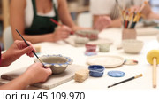 Girl hands paints bowl of clay during master class, close up. Стоковое видео, видеограф Яков Филимонов / Фотобанк Лори