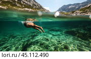 A swimmer dives into crystal clear water surrounded by stunning mountains on a sunny day. Стоковое AI-изображение, AI-художник Сергей Толмачёв / Фотобанк Лори