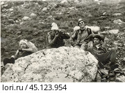 Мужчины отдыхают вовремя привала около большого камня в 1980-е годы. Стоковое фото, фотограф Retro / Фотобанк Лори