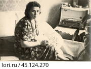 Женщина в платье сидит дома на диване и вышивает на пяльцах, СССР, 1970-е гг. Стоковое фото, фотограф Retro / Фотобанк Лори