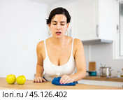 Young Chilean woman wiping dust from kitchen table. Стоковое фото, фотограф Яков Филимонов / Фотобанк Лори