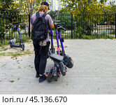 Перевозка нескольких электросамокатов с помощью одного из них (2024 год). Редакционное фото, фотограф Вячеслав Палес / Фотобанк Лори