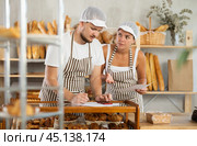 Man and woman sellers in bakery make calculations, work with paper documents and count using phone. Стоковое фото, фотограф Яков Филимонов / Фотобанк Лори