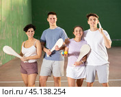 Two happy couples after playing paleta fronton on tennis court. Стоковое фото, фотограф Яков Филимонов / Фотобанк Лори
