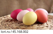 Easter colorful eggs in a basket on white wooden table. Burlap background. Happy Easter. Rustic, Eco concept. Dyed Eggs on a straw Napkin. Easter Centerpieces. Стоковое видео, видеограф Марина Демидюк / Фотобанк Лори