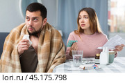 Woman taking care of sick husband suffering from flu. Стоковое фото, фотограф Яков Филимонов / Фотобанк Лори