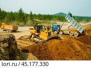 Самосвалы и бульдозер в процессе работы на строительной площадке. Стоковое фото, фотограф Павел Просянов / Фотобанк Лори