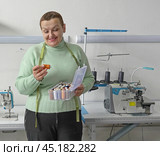 Женщина швея в швейном ателье выбирает нитки для шитья одежды. A female seamstress in a sewing studio selects threads for sewing clothes. Стоковое фото, фотограф Наталья Пеньшина / Фотобанк Лори