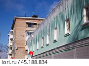 Огромные сосульки свисают с крыши дома (2022 год). Редакционное фото, фотограф Ольга Дубровская / Фотобанк Лори