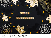 The inscription happy Halloween. Modern background with black bats, Golden leaves, cobwebs and wooden letters. Halloween with copy space for text. Flat lay, top. Стоковое фото, фотограф Photojuli / Фотобанк Лори