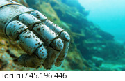 Robotic hand covered in barnacles rests on the ocean floor, hinting at a mysterious past, AI. Стоковое AI-изображение, AI-художник Сергей Старуш / Фотобанк Лори