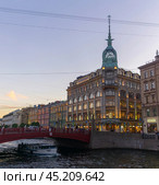 Evening view of the Red Bridge and Esders and Scheefhals building in Saint Petersburg (2024 год). Редакционное фото, фотограф Евгений Харитонов / Фотобанк Лори