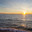 Baikal Lake in December at sunset. Snowy beach in Listvyanka village against backdrop of setting sun. Scenic seascape. Natural background. Outdoor recreation and travel along the lake shore. Стоковое фото, фотограф Виктория Катьянова / Фотобанк Лори