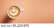 Minimalist coffee cup on peach fuzz colored table. Cup of coffee in Peach Fuzz color. top view, banner. color of year 2024. Peach Fuzz cup of cappuccino coffee. Стоковое AI-изображение, AI-художник Павел Муравьев / Фотобанк Лори