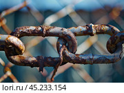Old rusty chain link fence corroding in the sunlight. Стоковое AI-изображение, AI-художник Иван Рябоконь / Фотобанк Лори