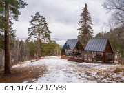 A picturesque winter picnic location featuring snowy scenery and charming, rustic shelters Gremyachaya Griva Park, Russia Krasnoyarsk November 17, 2023. Редакционное фото, фотограф Владимир Разгуляев / Фотобанк Лори