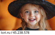 Happy smiling little girl wearing a witch costume to celebrate Halloween on yellow background. Halloween for children, space for text. Kids trick or treating. Стоковое AI-видео, аниматор Ирина Михайличенко / Фотобанк Лори