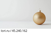 Golden Christmas ball isolated on a white, free space for text. Стоковое AI-изображение, AI-художник Елена Зубкова / Фотобанк Лори