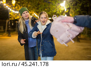 Street thief stealing backpack of scared teenage girl walking with mother. Стоковое фото, фотограф Яков Филимонов / Фотобанк Лори