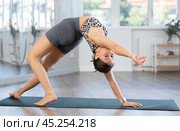 Young woman practicing vinyasa yoga in studio. Стоковое фото, фотограф Яков Филимонов / Фотобанк Лори