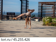 A young woman in a tracksuit performs physical exercises in a summer park. Стоковое фото, фотограф Андрей Аркуша / Фотобанк Лори