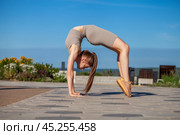 Fitness portrait young athletic woman doing gymnastics on blue sky background. Стоковое фото, фотограф Андрей Аркуша / Фотобанк Лори
