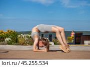 A young woman in a tracksuit performs physical exercises in a summer park. Стоковое фото, фотограф Андрей Аркуша / Фотобанк Лори
