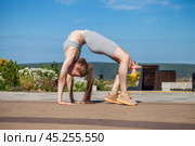 A young woman in a tracksuit performs physical exercises in a summer park. Стоковое фото, фотограф Андрей Аркуша / Фотобанк Лори