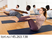 Young woman doing static exercise during group fitness training. Стоковое фото, фотограф Яков Филимонов / Фотобанк Лори