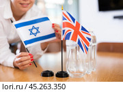 Office coordinator setting flags of Israel and United Kingdom on table. Стоковое фото, фотограф Яков Филимонов / Фотобанк Лори