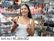 Interested young woman viewing Spanish dancer statuettes in souvenir store in Barcelona. Стоковое фото, фотограф Яков Филимонов / Фотобанк Лори