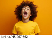 extremely whim Upset black curly haired boy in t shirt screaming and crying or very emotional expression sings songs with opened mouth and closed eyes against orange color wall. Стоковое AI-изображение, AI-художник Sergey Grishin / Фотобанк Лори