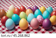 Group of colorful easter eggs laid on blanket. Multi colored easter eggs against bright wool blanket background. Concept of family traditions, Pascha, Resurrection Sunday, Christian cultural holiday. Стоковое AI-изображение, AI-художник Sergey Grishin / Фотобанк Лори