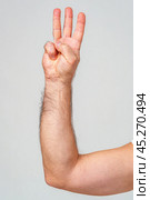 Hand gesture indicating the number three against a plain background. Стоковое фото, фотограф Сергей Толмачёв / Фотобанк Лори